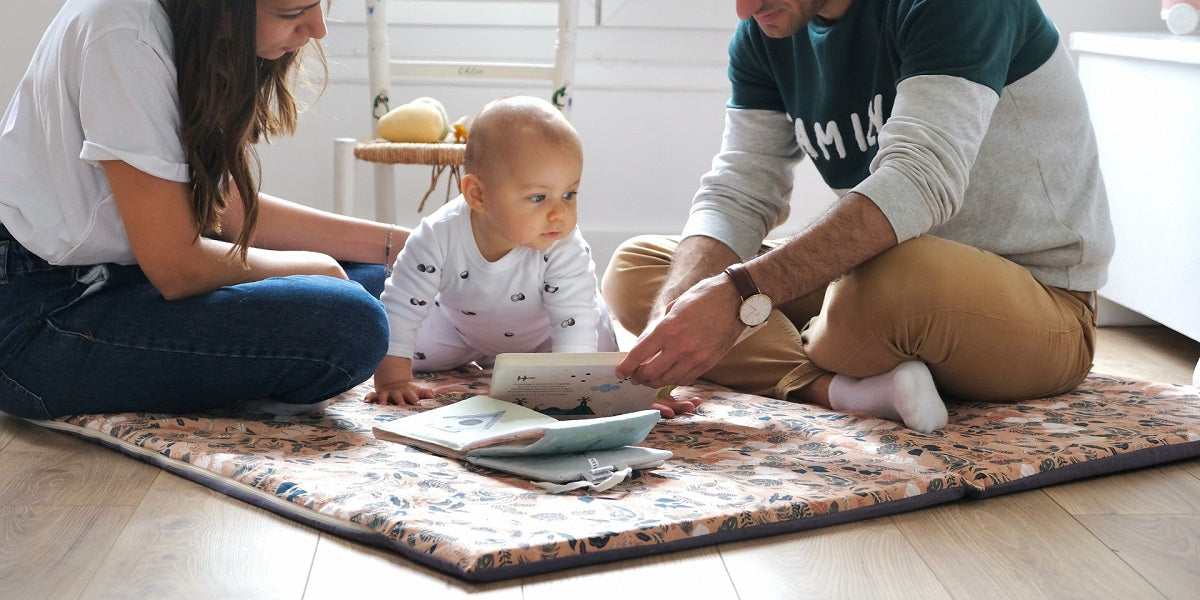 maman papa et bébé dans un tapis d'eveil